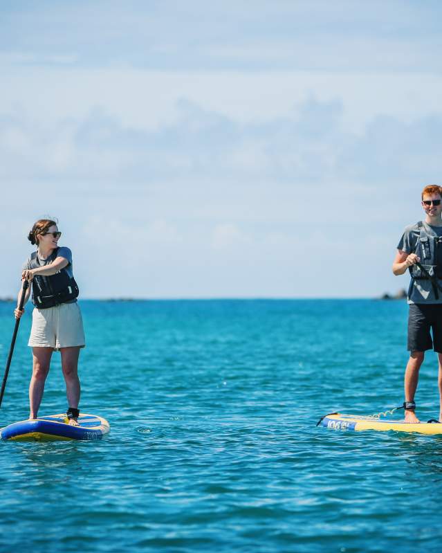 Two teenagers paddleboarding