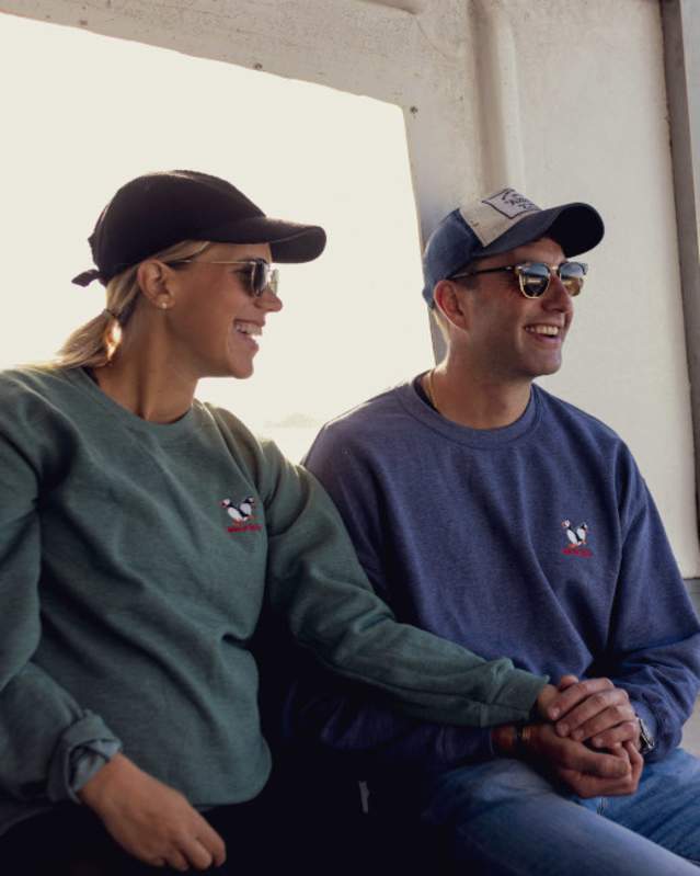 IOS Nav Landscape Large - Season - Autumn - Tom Young Oct22 couple wearing penguin sweater on boat 952x650