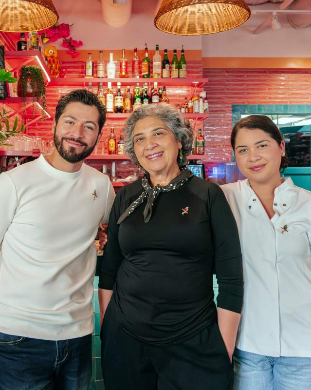 Three people standing side by side, posing for a photo