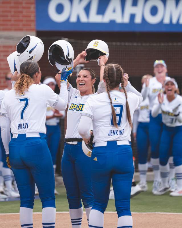 OKC Spark softball team celebrating together during a game