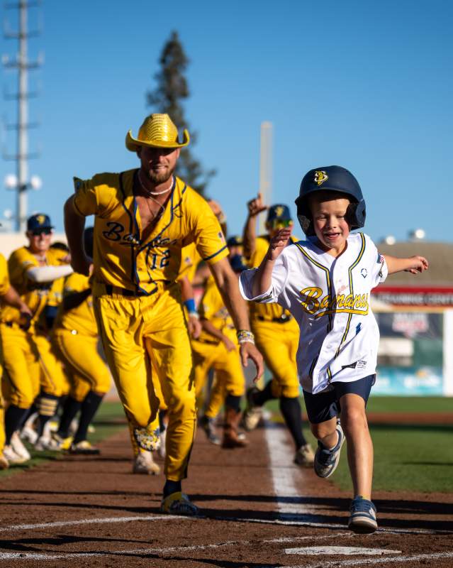 Savannah Bananas and child running on the field