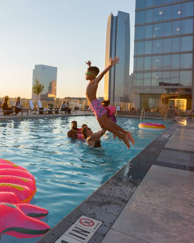 Boy jumping into the rooftop pool at the OMNI Hotel