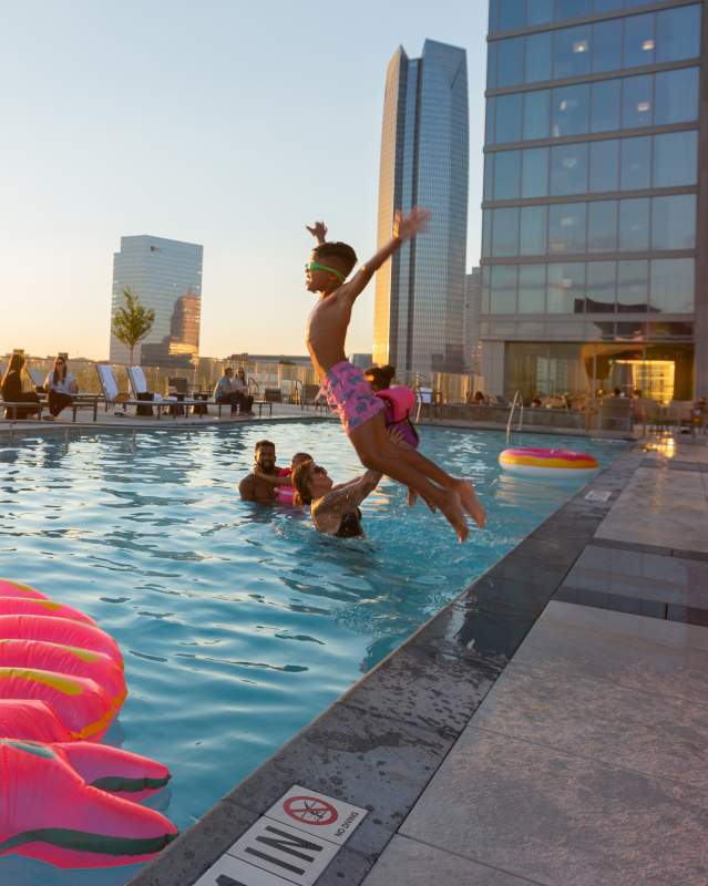Boy jumping into the rooftop pool at the OMNI Hotel