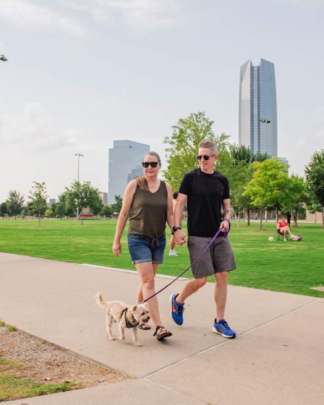 Couple walking their dog in Scissortail Park