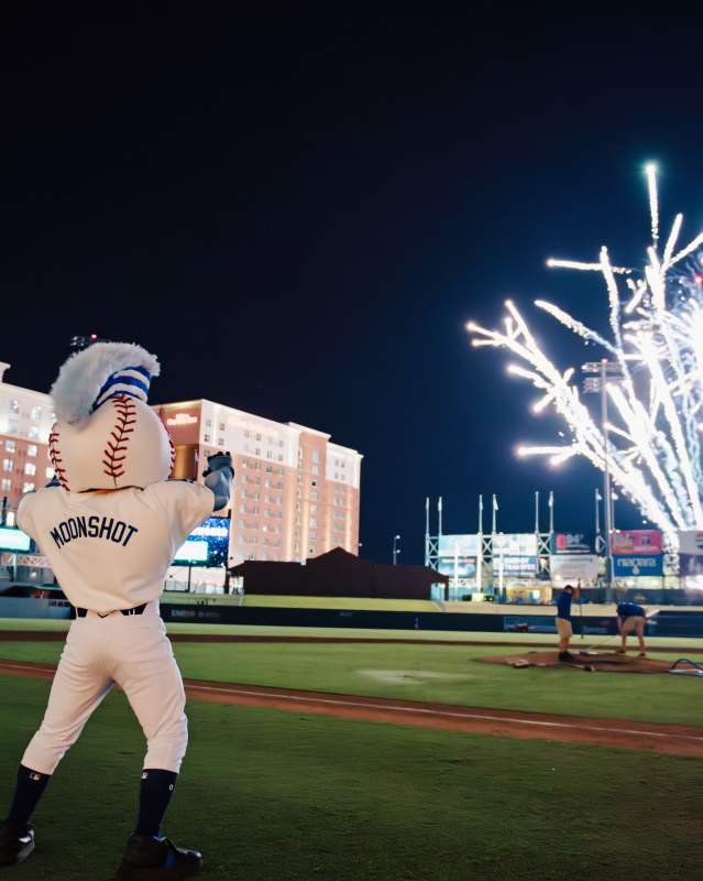 Photo of the Oklahoma City Comets mascot, Moonshot looking at fireworks in the sky after a Comets game.