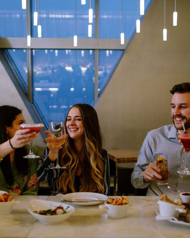 A group of friends raising their glasses to cheers at Vast