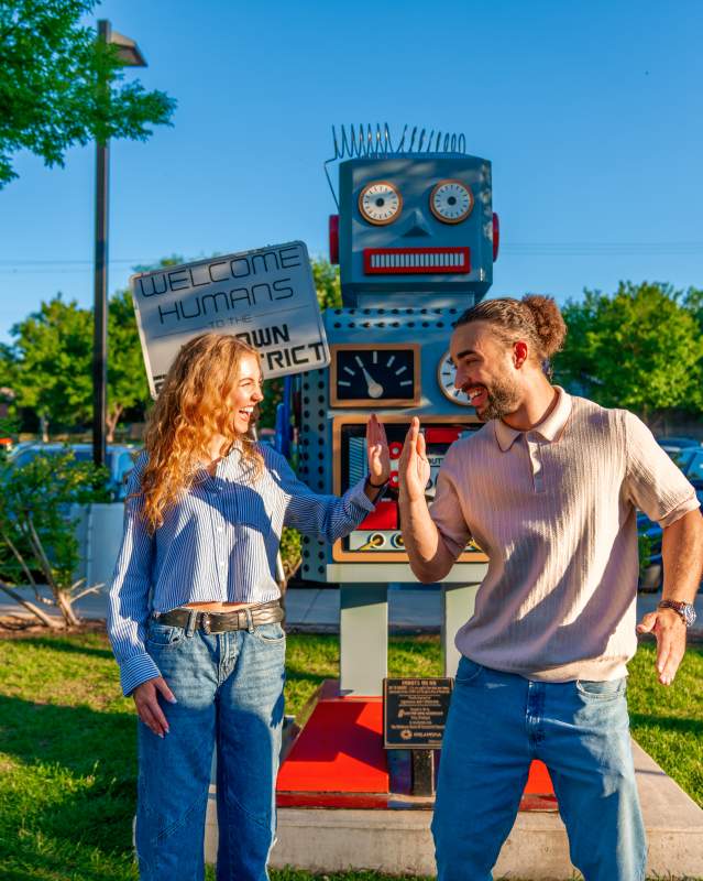 Two people posing in front of Robot on Route 66 in Oklahoma City