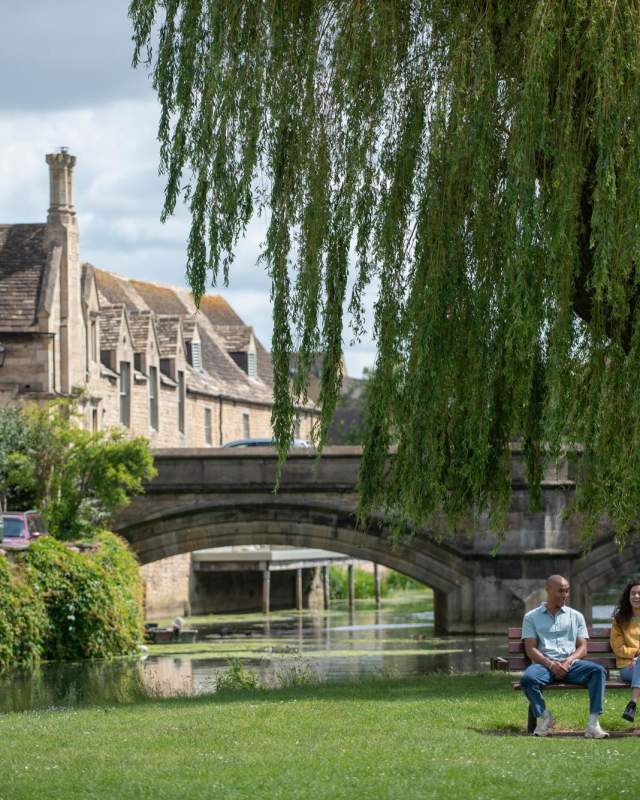 Two people sat on park bench in Stamford town centre