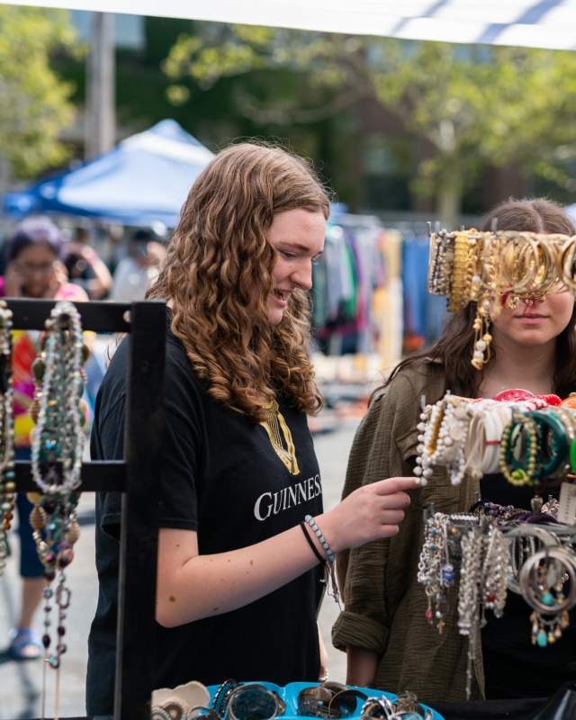Young women shopping during Mitten Vintage event at Tulip City Walls Mural Fest