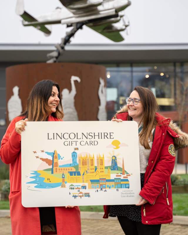 2 lovely people holding a giant lincolnshire gift card at the International Bomber Command Centre