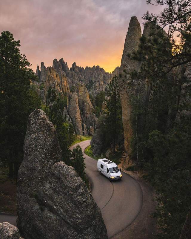 View of a van cruising through the granite pillars of Needles Highway in Custer State Park