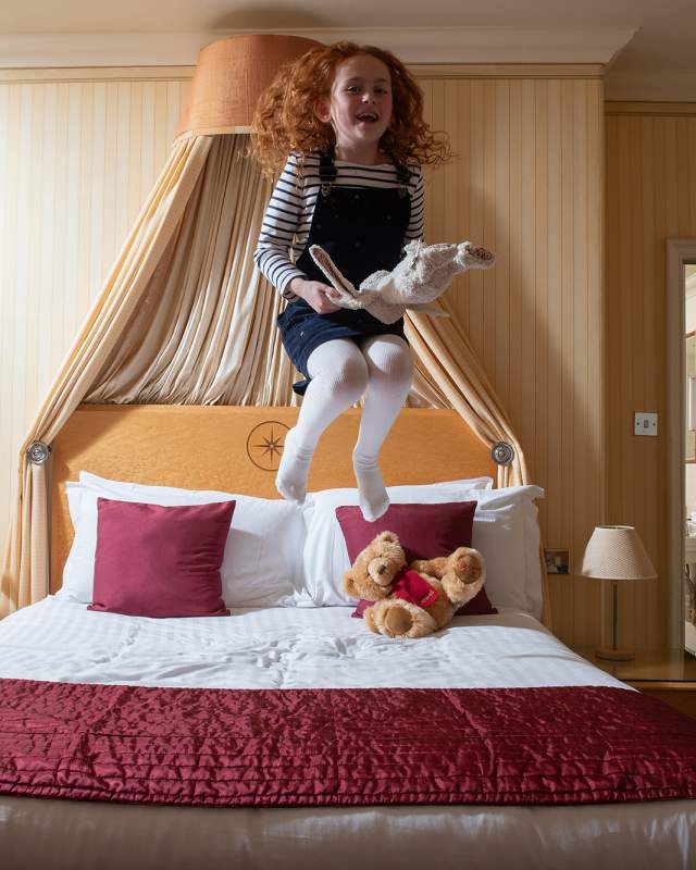 Young girl jumping on the bed
