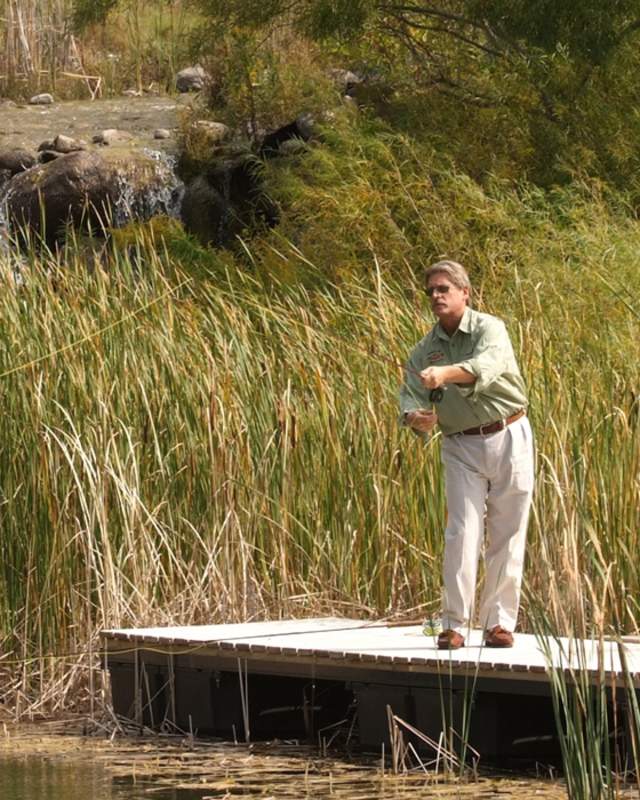 A man fly fishing from a dock