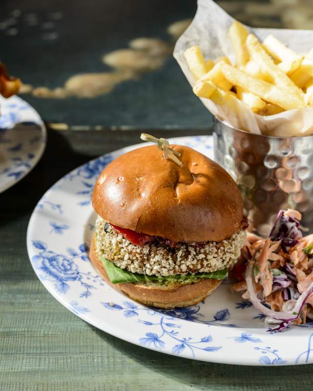 A vegan burger meal presented on a table next to a chicken burger meal