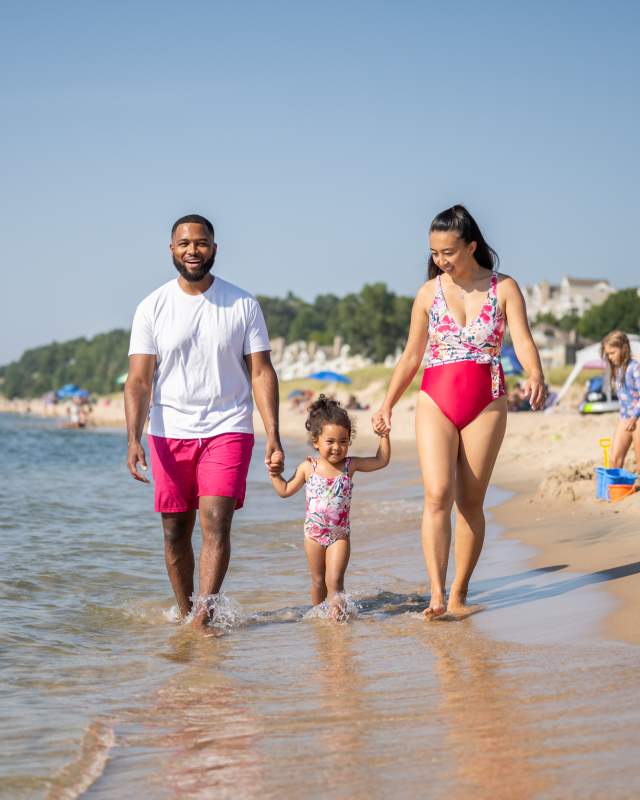 Family walking along the water at Holland State Park