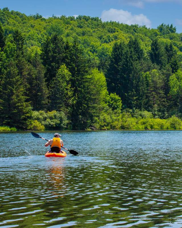 A person kayaking on a lake on a sunny day