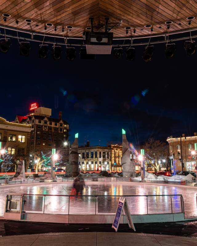 Ice skating rink at night in Main Street Square in downtown rapid city surrounded by lights and historic buildings