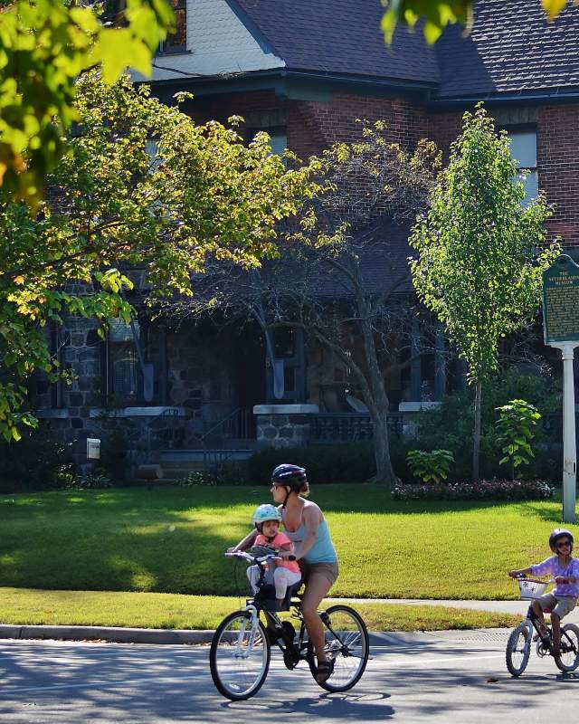 Family biking in front of Centennial Inn