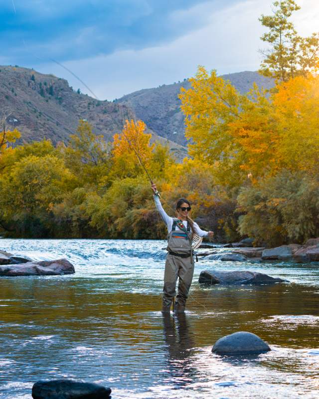 Woman fly fishing in Clear Creek in the Fall in Golden