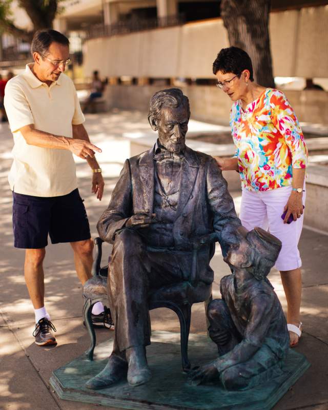 couple exploring the abraham lincoln statue, part of the city of presidents tour in rapid city, sd