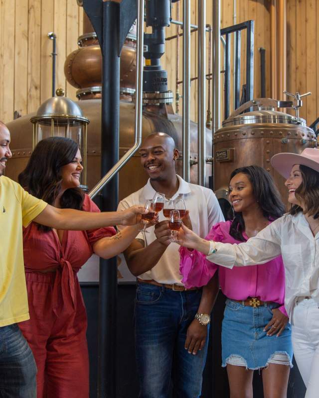 A group of five people enjoying a sample on the Kentucky Bourbon Trail.