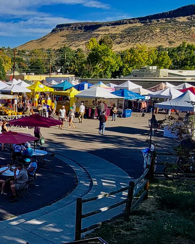 Looking out over the Golden CO farmers market vendors with North Table Mountain in the background on a sunny summer day.