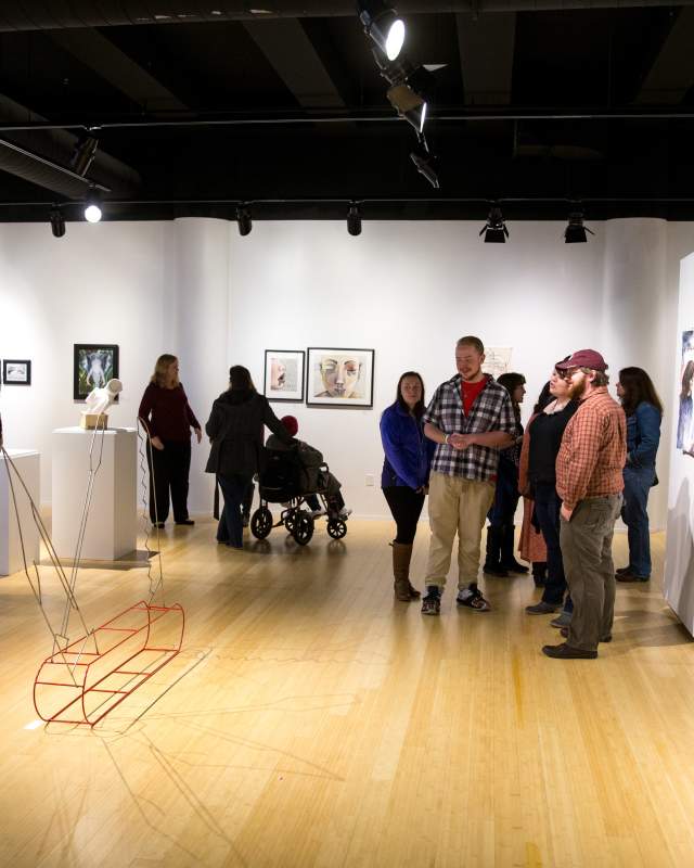 People mingle among various pieces of art at the Kutztown University Gallery