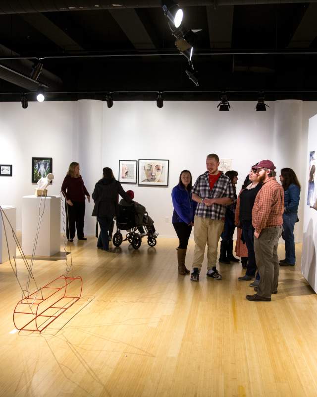 People mingle among various pieces of art at the Kutztown University Gallery