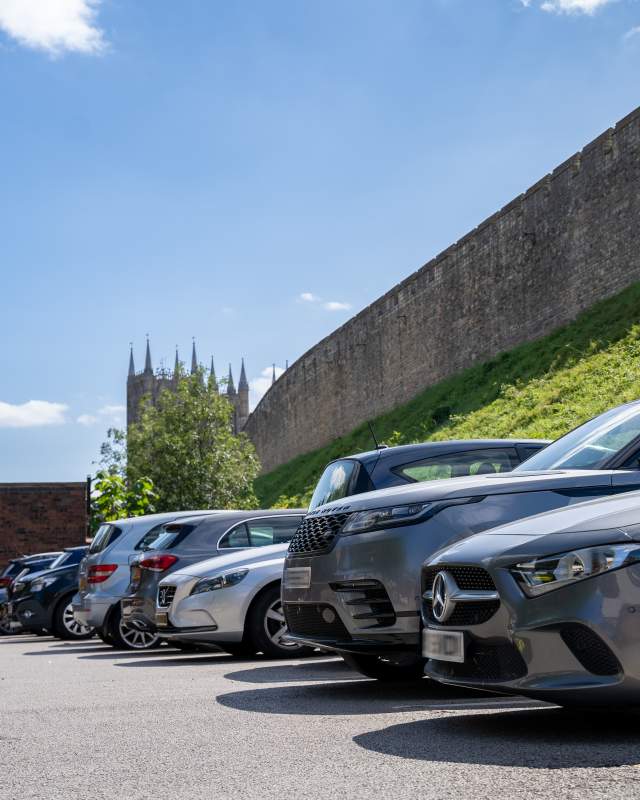 Cars parked outside of the Lincoln Castle walls