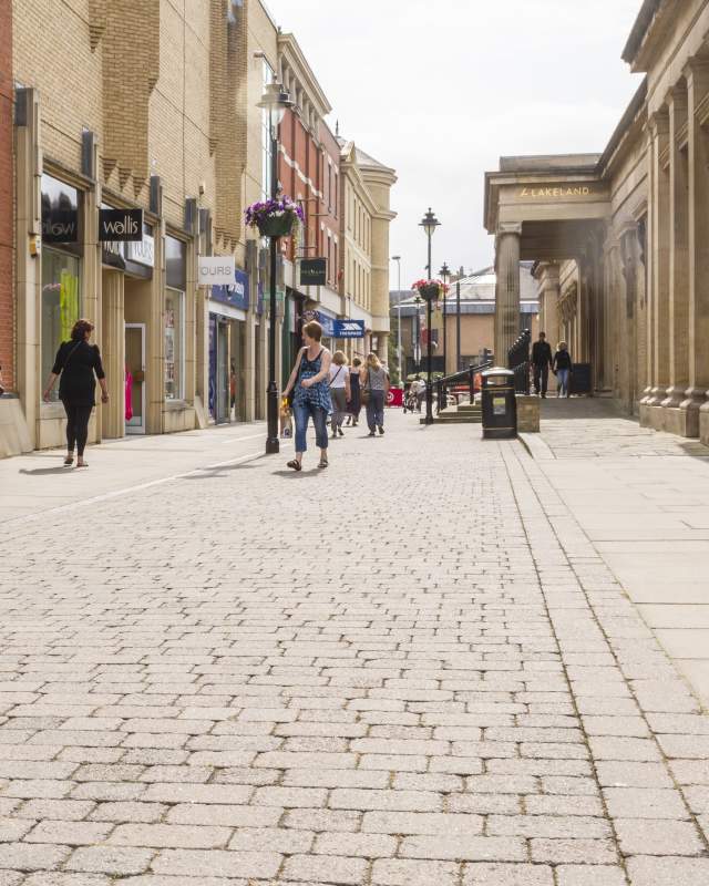 People walking down a lively shopping street