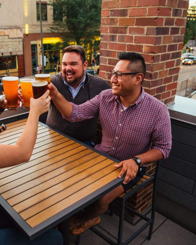 Friends clinking beer glasses at brewery
