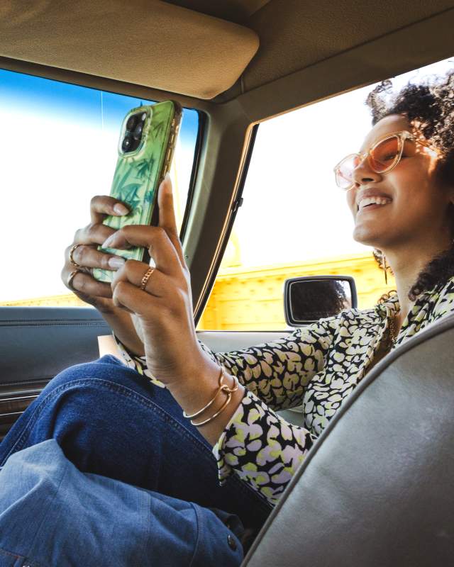 A girl in the passenger seat of a car taking a selfie