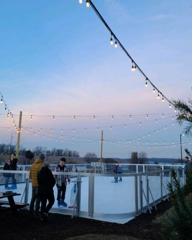 People ice skating under the twinkle lights at Folino during sunset