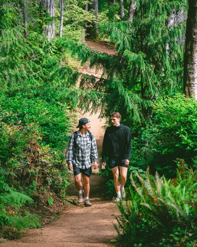 Two men walking on a dirt path to Ammonite Falls