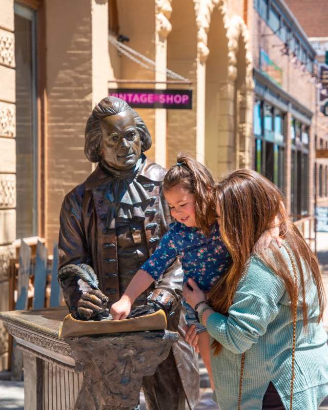 Woman and her daughter look at statue of Thomas Jefferson in Rapid City.