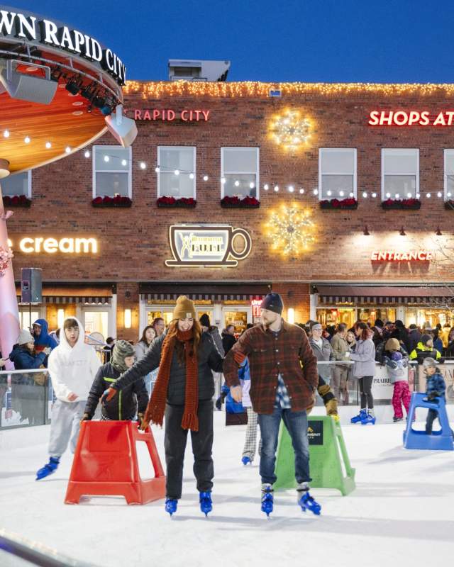 people ice skating at main street square in rapid city, sd during winter market event