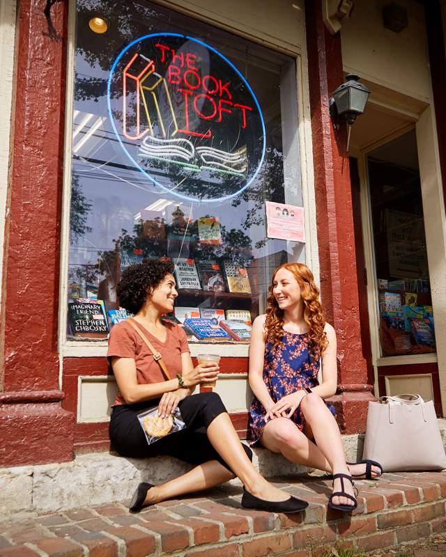 Two friends sitting outside The Book Loft in German Village