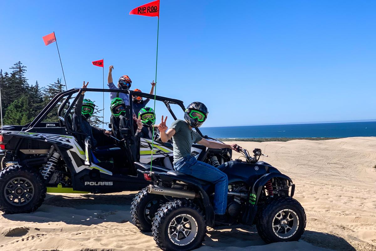 Two off road vehicles full of adventurous people on the Oregon Dunes.