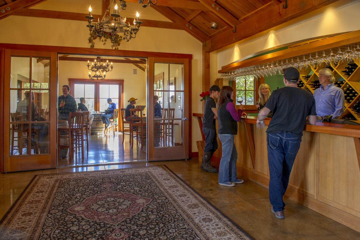 A wine tasting room with many patrons.