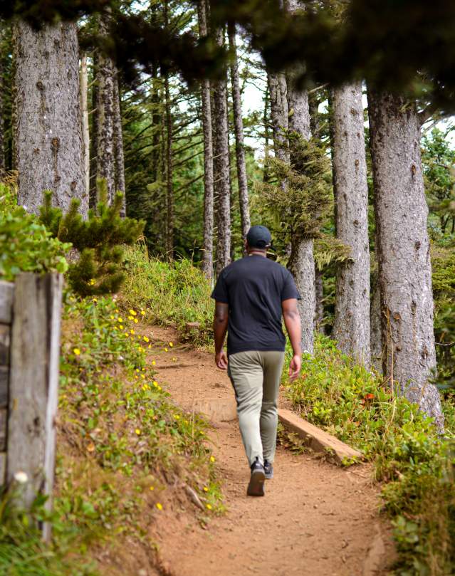 Man walks up a hiking trail in the coastal forest near Florence, Oregon.