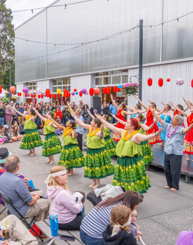 Hula performances outside with a full crowd around the stage.