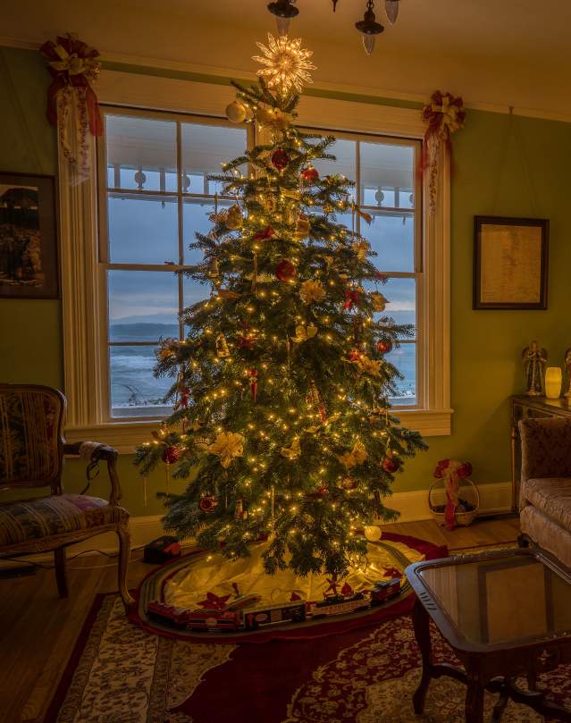 A lighted Christmas tree adorns a living room decorated for Christmas at the Heceta Head Bed and Breakfast.