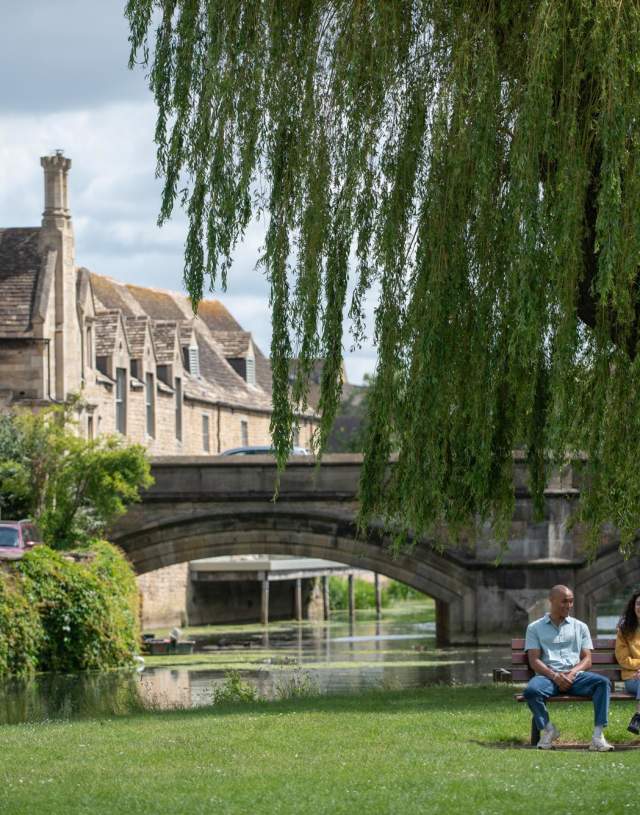 Two people sat on park bench in Stamford town centre