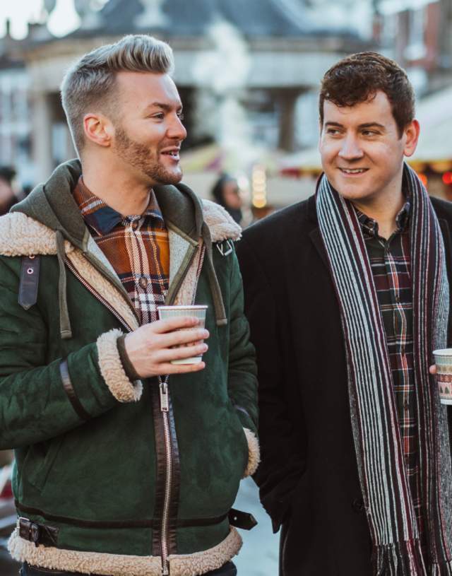 Two friends drinking hot chocolates whilst strolling around the Beverley Festival of Christmas in East Yorkshire