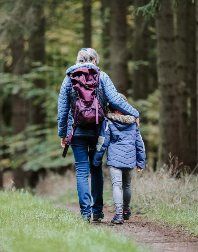 Familie som går tur i skogen