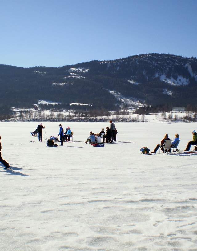 Ice fishing on lake Randsfjorden on a beautiful winter day