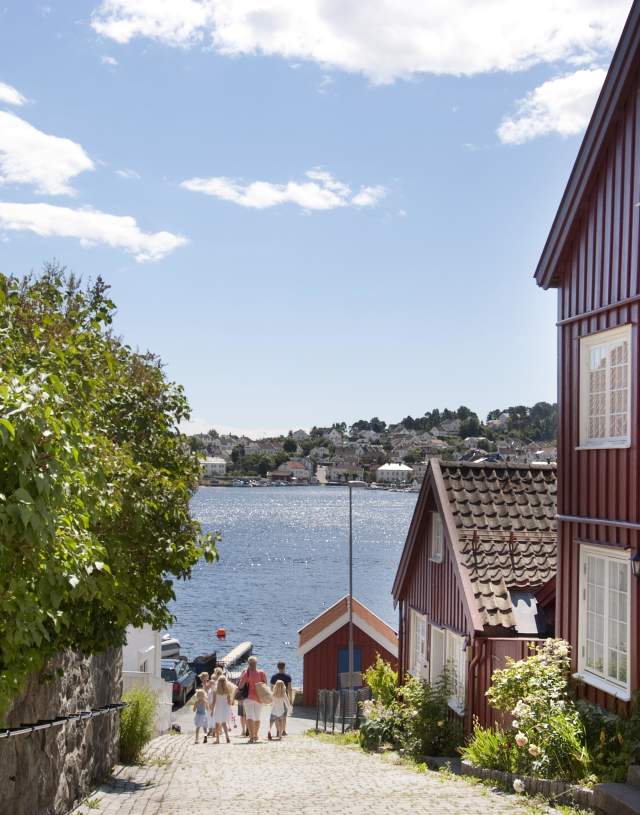 People walking among houses at Tyholmen in Arendal