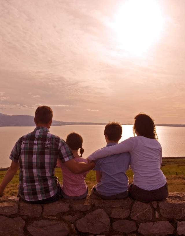 Mum, dad and two kids watching the sunset on the Great Orme