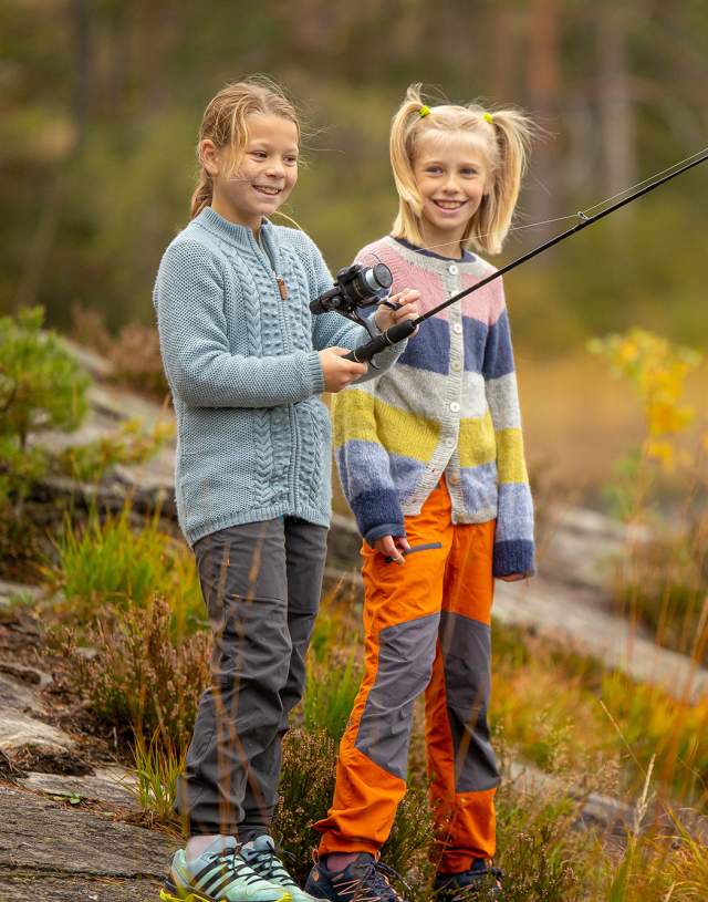 To jenter som fisker ved et vann