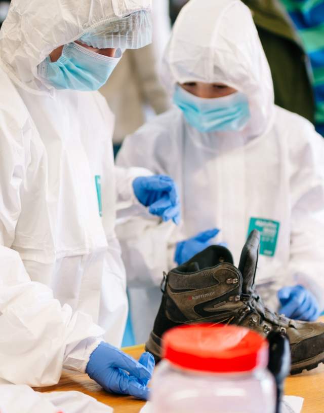 Two children in which suits and masks study a reaction